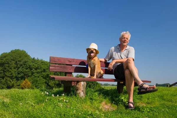 Man and dog with hat — Stock Photo, Image