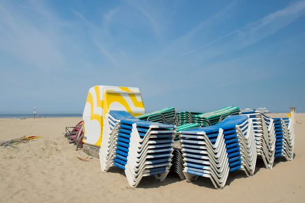 Gestapelde lege bedden op het strand — Stockfoto