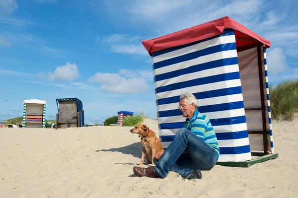 Man med hund på stranden borkum — Stockfoto