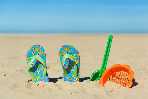 Flip flops and toys at the beach