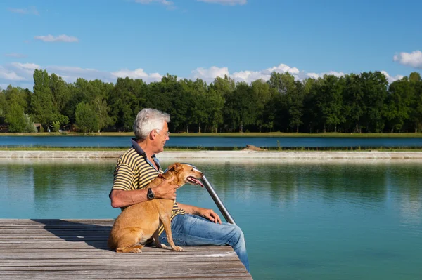 Man met hond op pier — Stockfoto