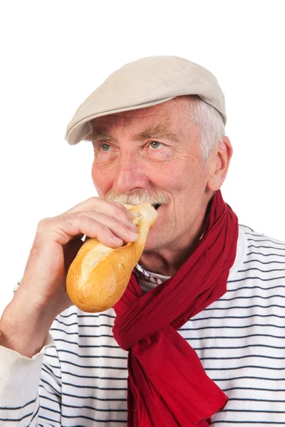 Homme âgé mangeant du pain français — Photo