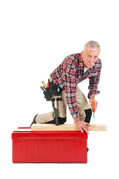 Senior manual worker sawing — Stock Photo, Image