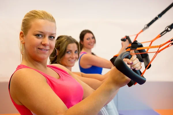 Mujer joven haciendo entrenamiento en suspensión — Foto de Stock