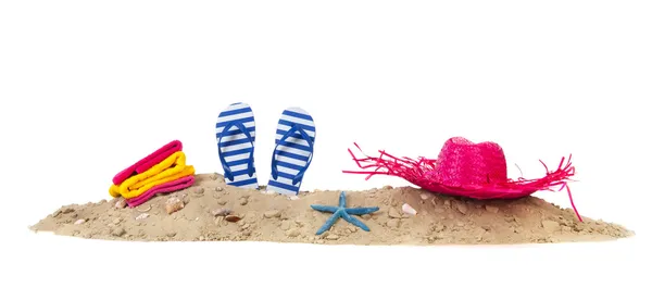 Playa de arena con toallas chanclas y sombrero — Foto de Stock