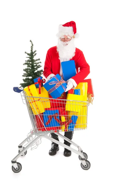 Jultomten att sätta en gåva i shopping caart — Stockfoto