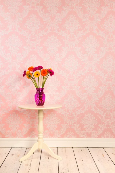 Vintage τοίχο και ξύλινο πάτωμα με λουλούδια βάζο στο τραπέζι — Φωτογραφία Αρχείου