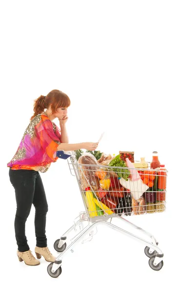 Vrouw met winkelen winkelwagen volledige zuivel kruidenier lezen lijst — Stockfoto