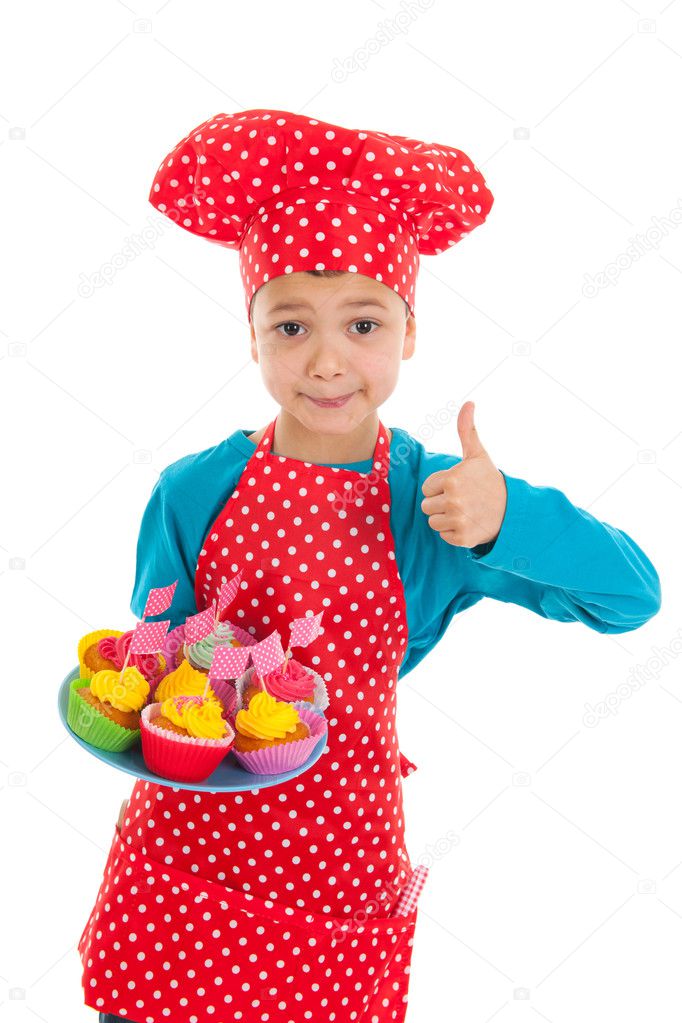 Studio portrait boy as little cook with cupcakes