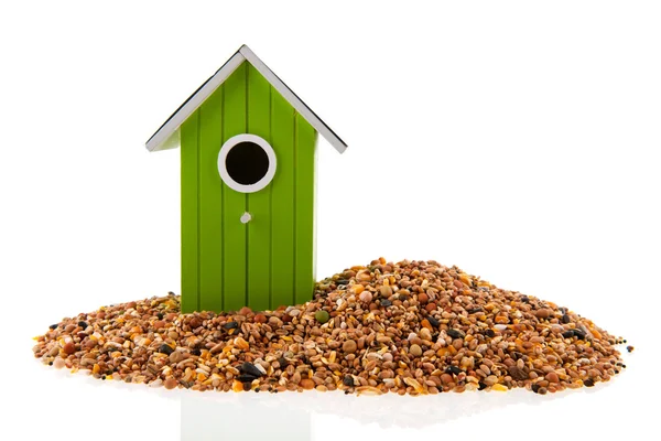 Grön och röd fågel hus med utsäde — Stockfoto
