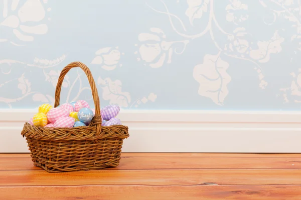 Basket easter eggs in room with blue vintage wall paper — Stock Photo, Image