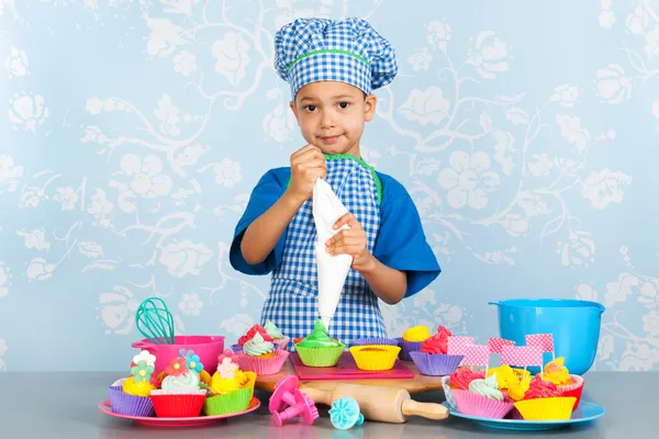 Little boy baking cupcakes