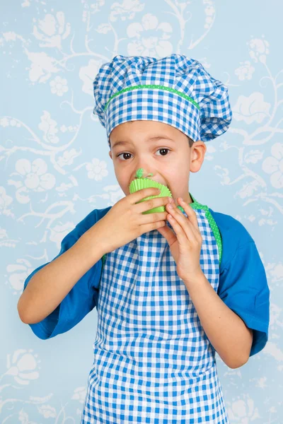 Little boy in apron baking cupcakes — Stock Photo, Image
