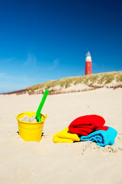Plaża z zabawek i latarnia morska — Zdjęcie stockowe