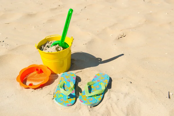 Zabawki i klapki na plaży — Zdjęcie stockowe