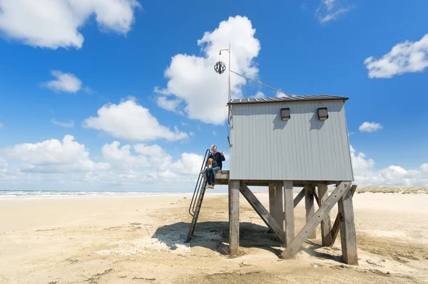 Homme et chien à la maison de noyade à la plage — Photo