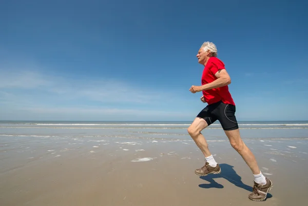 Senior löpare på stranden — Stockfoto