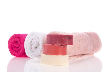 Beyaz arka planda sabunlu pembe havlular.