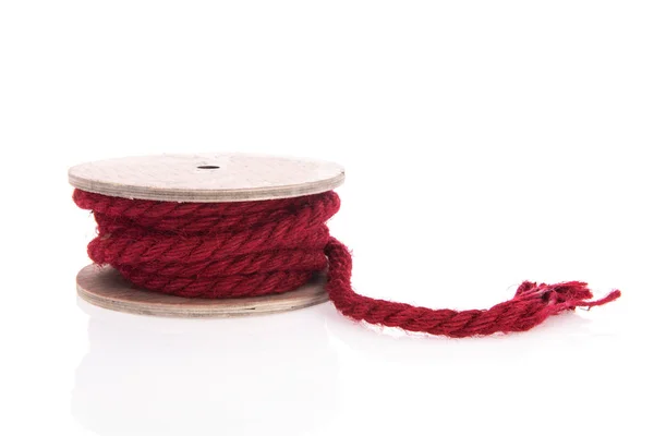 白い上に隔離された木製のロール上のシンプルな赤いロープ — ストック写真