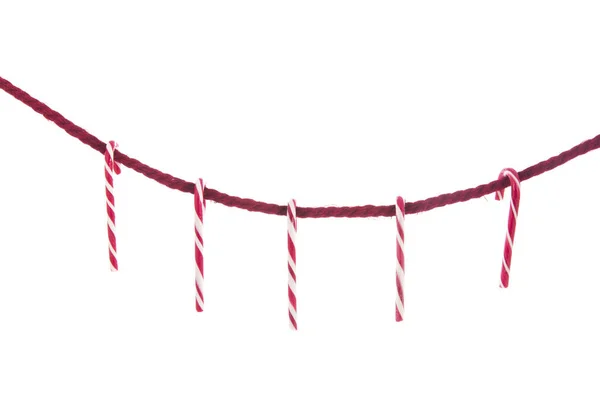 白の上に隔離されたクリスマスキャンディーの杖を持つシンプルな赤いロープ — ストック写真
