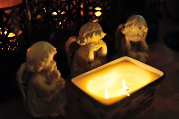 Three angels around a candle — Stock Photo, Image