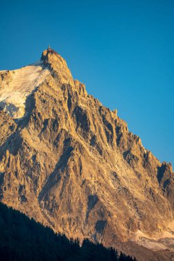 The panorama of Les Aiguilles towers in sunset light - Grands Charmoz, Aiguille du Grepon, Aiguille de Blaitiere, Aiguille du Plan and Aiguille du Midi.