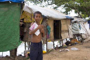 Boy in slum holding book want to go school clipart
