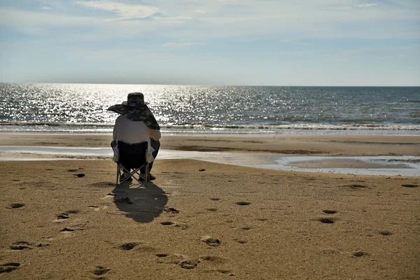 Kumsalda gün batımını izlemek oturan son adam — Stok fotoğraf