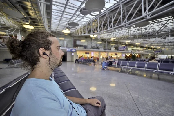 Jonge man zijn vlucht wachten in de luchthaven lounge — Stockfoto