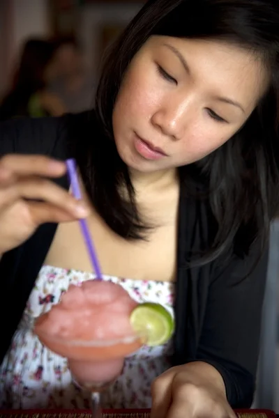 Asian woman drink cocktail alone