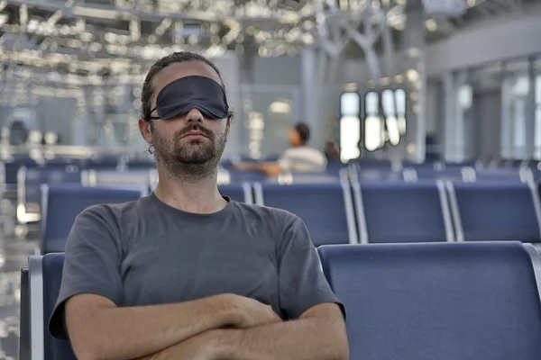 Sleeping in airport with eye cover — Stock Photo, Image