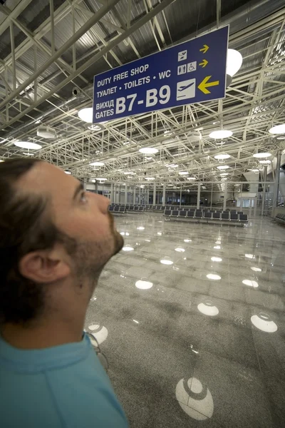 Man looking billboard in airport — Stock Photo, Image