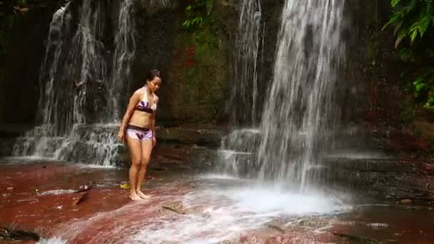 Сексуальная женщина, проходящая через водопад в тропическом лесу Борнео — стоковое видео