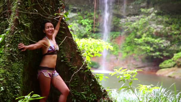 sexy dívka šikmou obrovský strom v deštném pralese pozadí vodopád