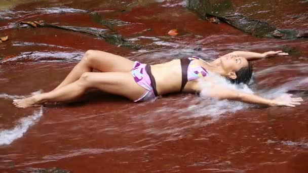 Ragazza sexy con bikini sdraiato nel fiume cascata — Video Stock