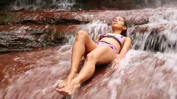 Sexy meisje met bikini liggen in waterval rivier — Stockvideo