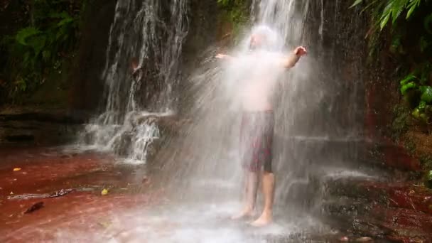 Caucasian man taking a shower in waterfall — Stock Video