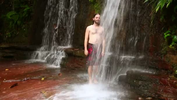 Caucasian man taking a shower in waterfall — Stock Video