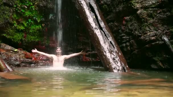 Білий чоловік насолоджується водоспадом під водоспадом — стокове відео