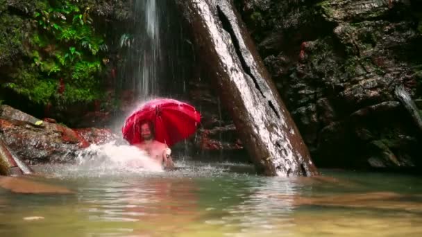 Férfi esernyővel vízesés borneo esőerdők — Stock videók