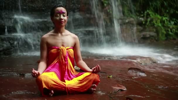 Meditating with Facial Painting in borneo rainforest waterfall — Stock Video