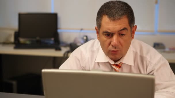 Businessman using laptop in office, calculating — Stock Video