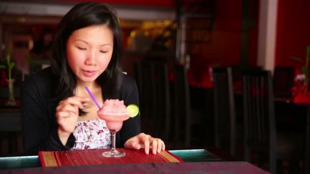 Asiatique jeune femme boire cocktail seul au bar — Video