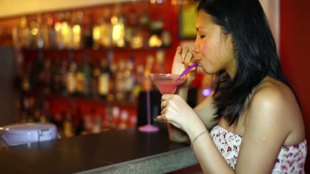 Asiática joven beber cóctel solo en el bar — Vídeos de Stock