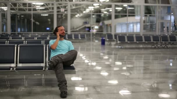 Genç adam havaalanında telefonda konuşuyor — Stok video