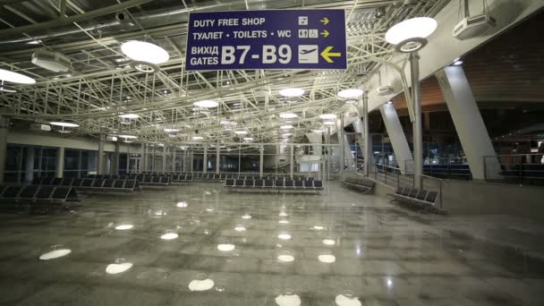 Joven mirando la dirección de la cartelera en el aeropuerto — Vídeos de Stock