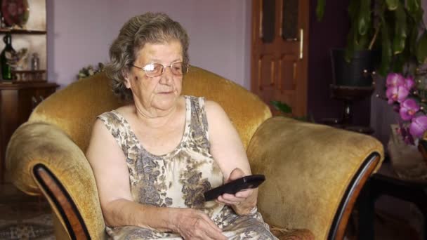 Old retired woman watching television