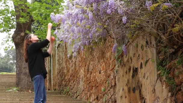 Mooi meisje spelen met bloemen op de straat — Stockvideo