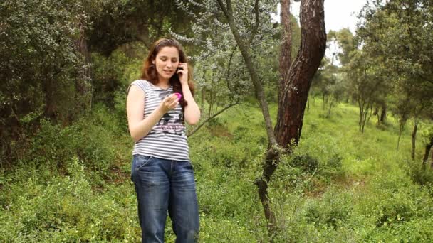 Красивая девушка разговаривает по телефону в сельской местности — стоковое видео