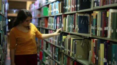 raflar arasında dolaşıp kız öğrenci